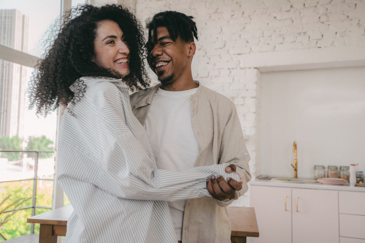 A couple laughing together in a bright kitchen
